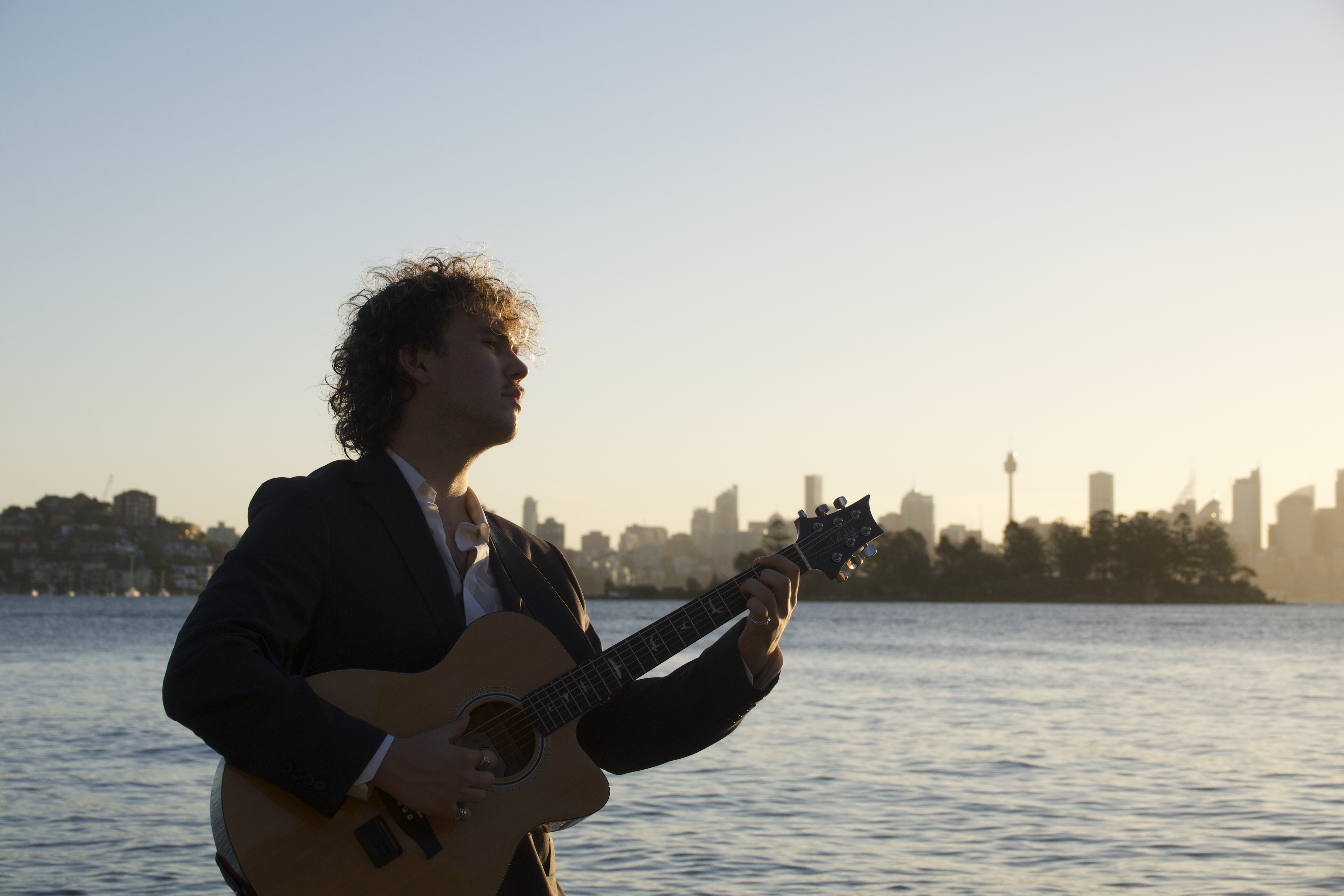Julian Moss playing guitar at Sydney Harbour